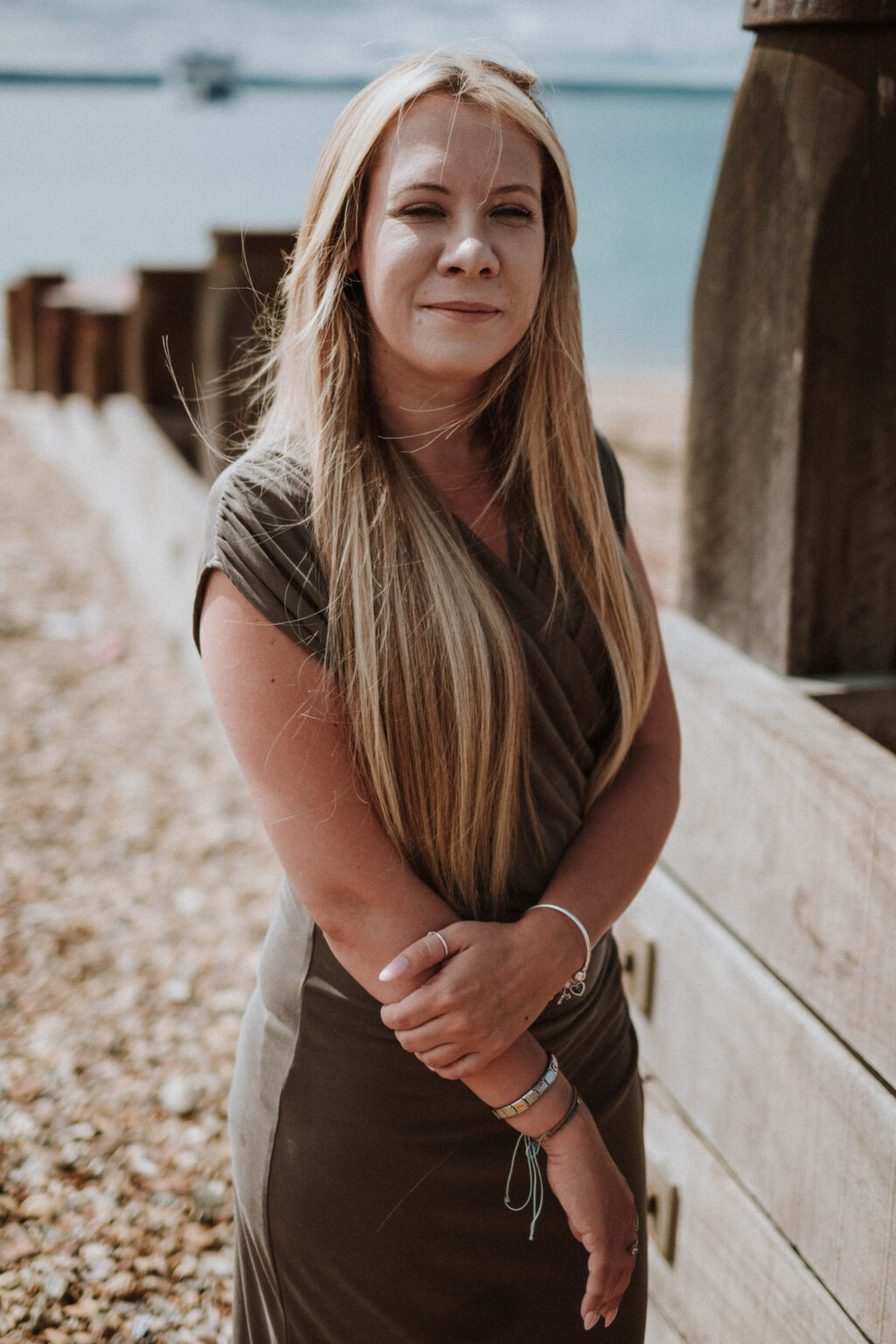 Danielle Hunter standing by the groynes on a shingle beach